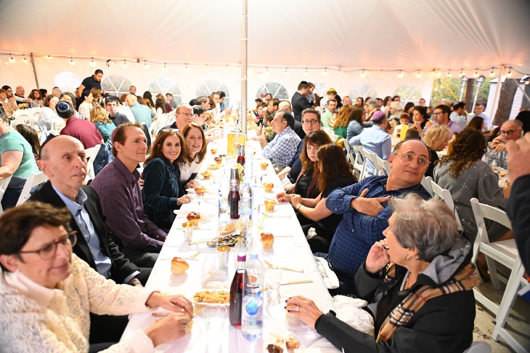 A full tent of families at the Shabbat table